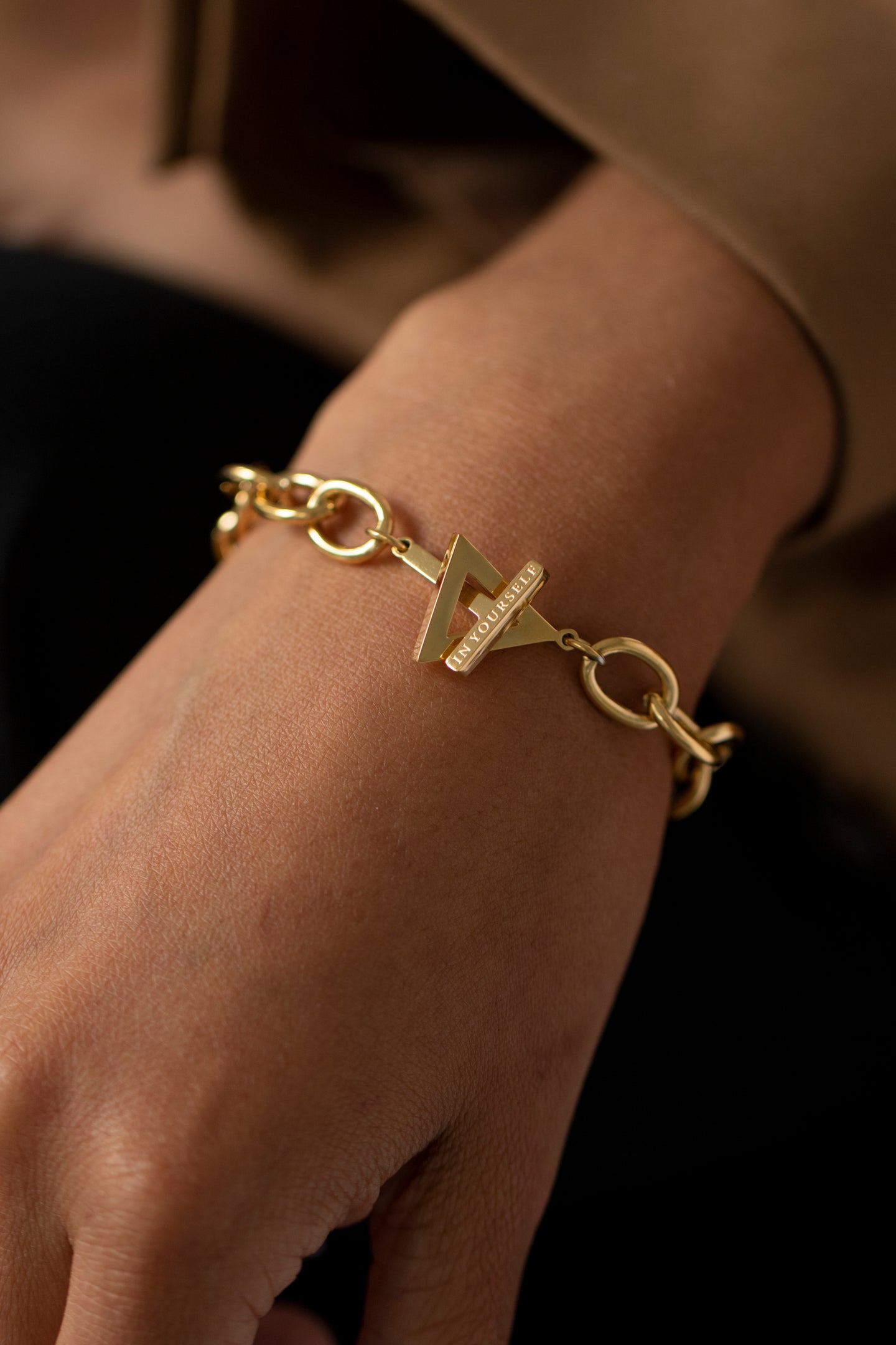 Gold chunky meaningful bracelet on woman's wrist