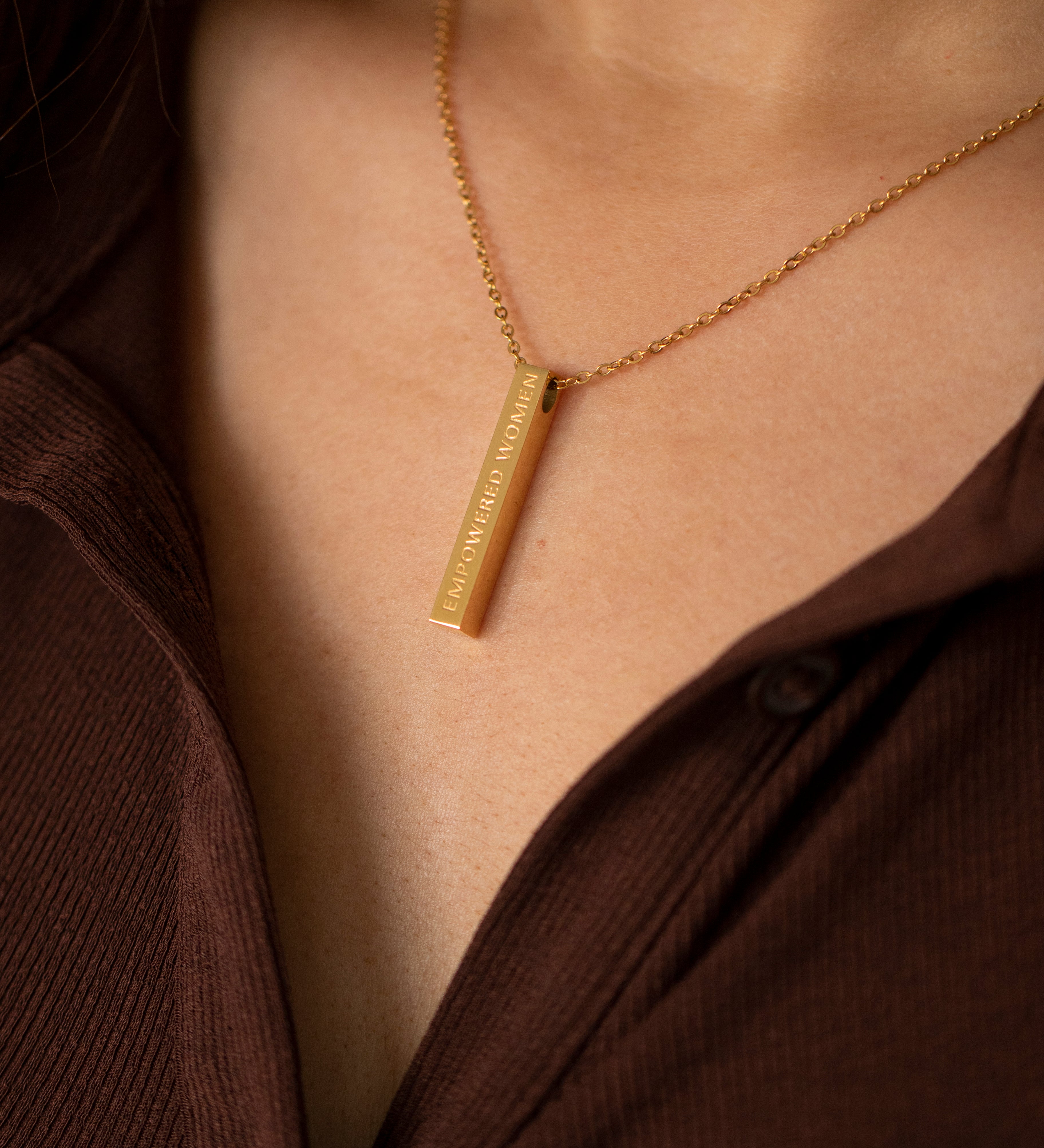 Woman wearing gold empowering necklace