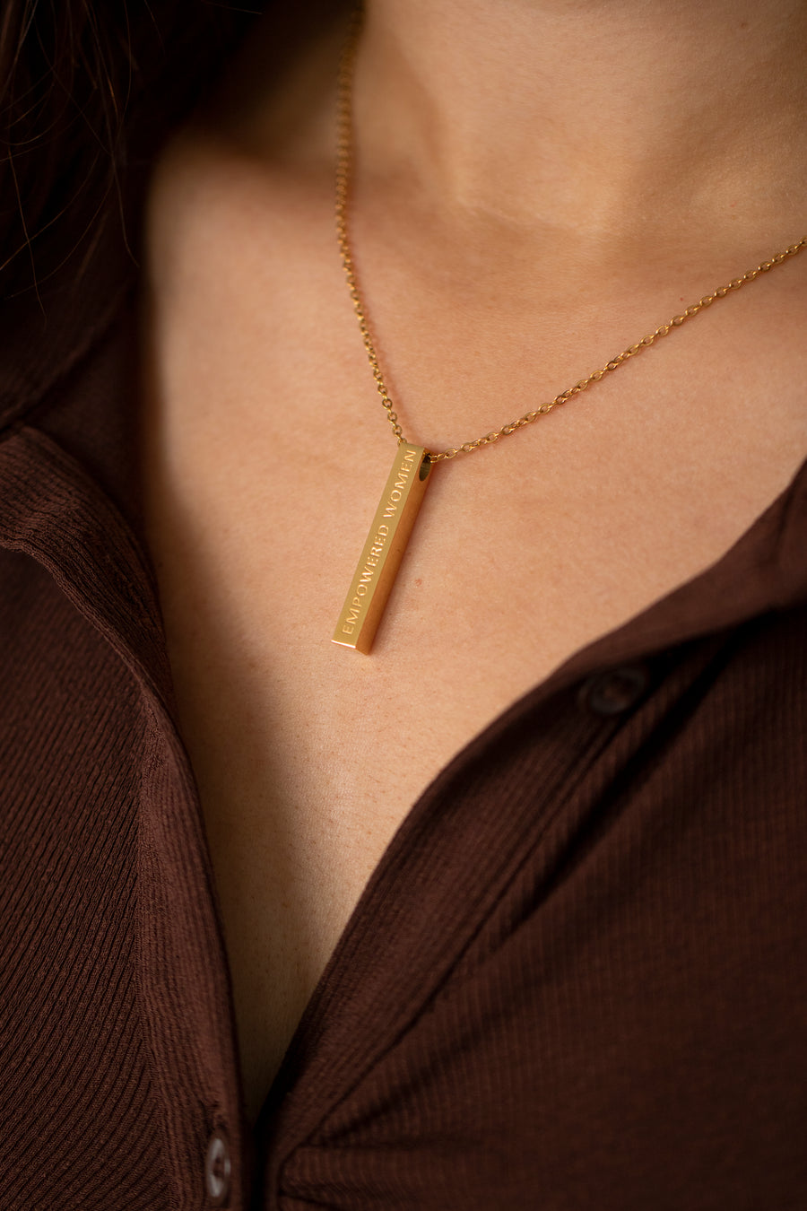 Woman wearing gold empowering necklace